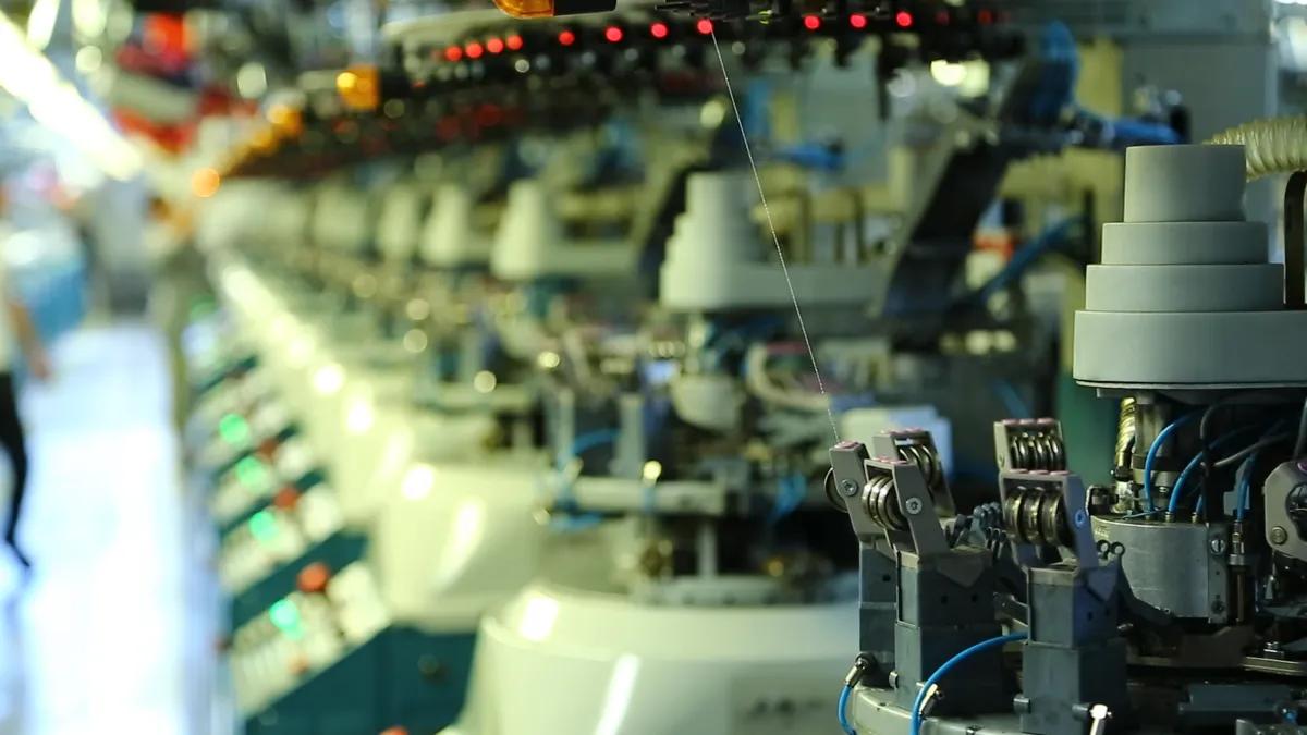 Row of knitting machines in operation on the Sokko factory floor