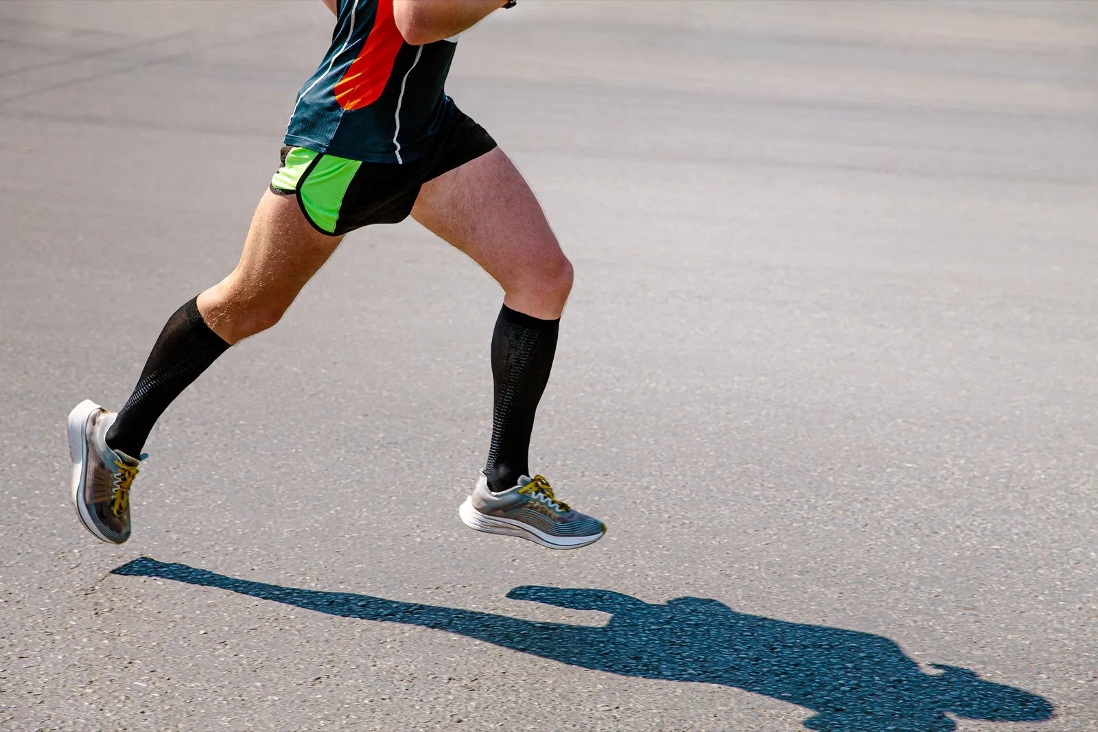 Runner wearing tall compression sport socks mid-stride
