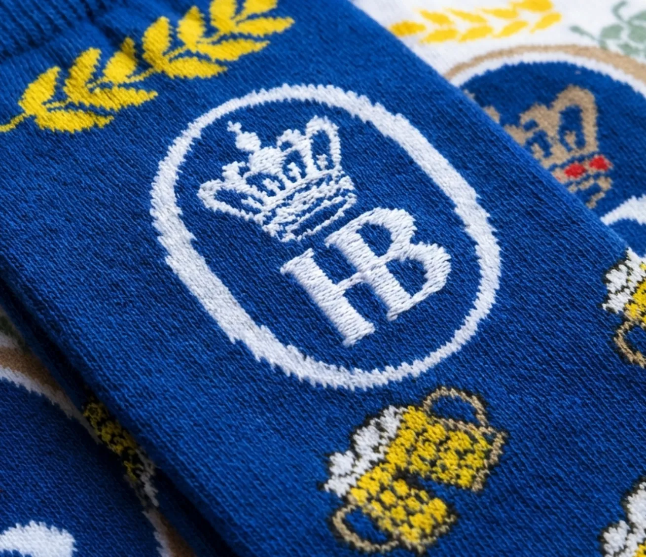 Close-up of a custom sock showing a crown and monogram crest knitted into the fabric with jacquard, with individual stitches visible